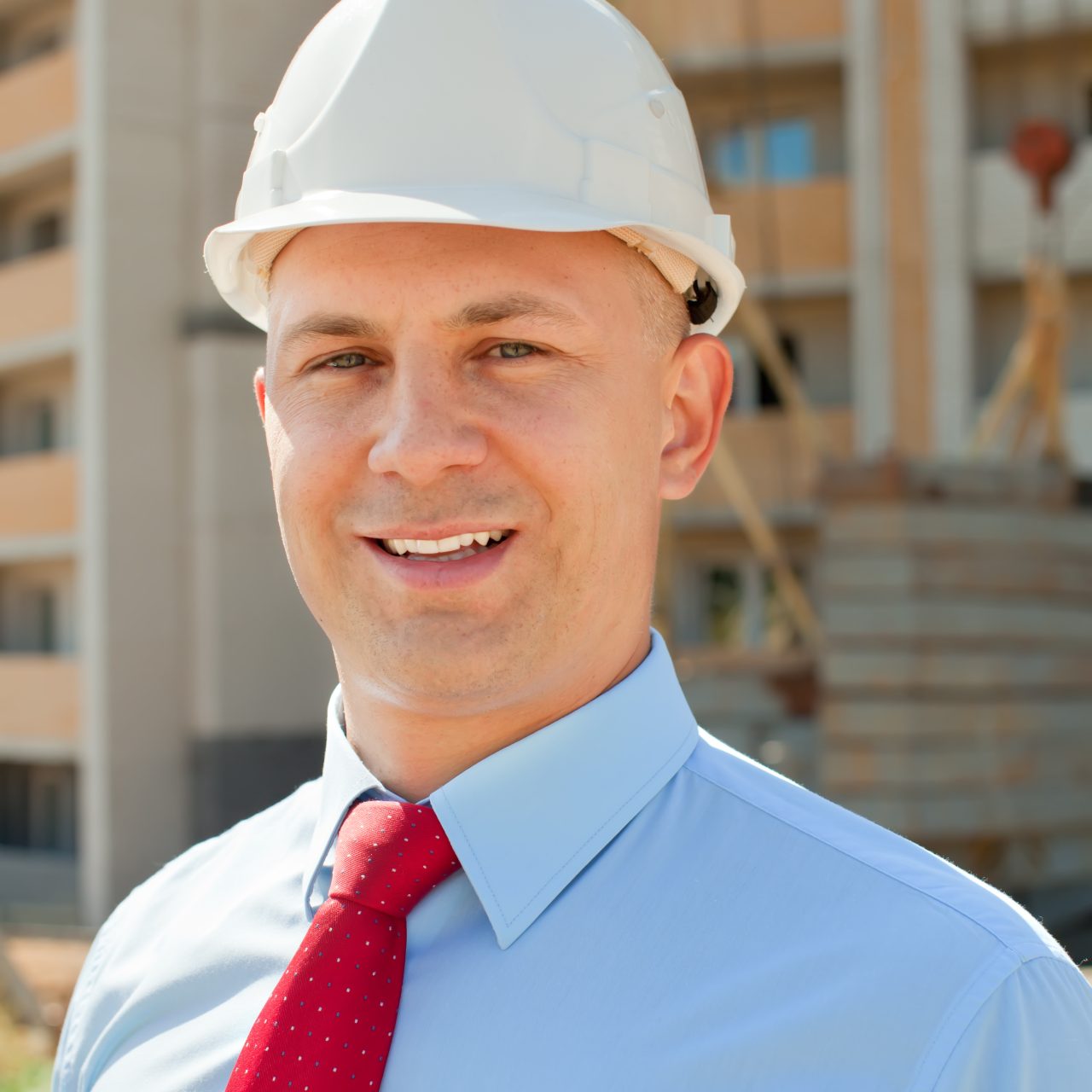 Happy builder in hardhat works on the building site