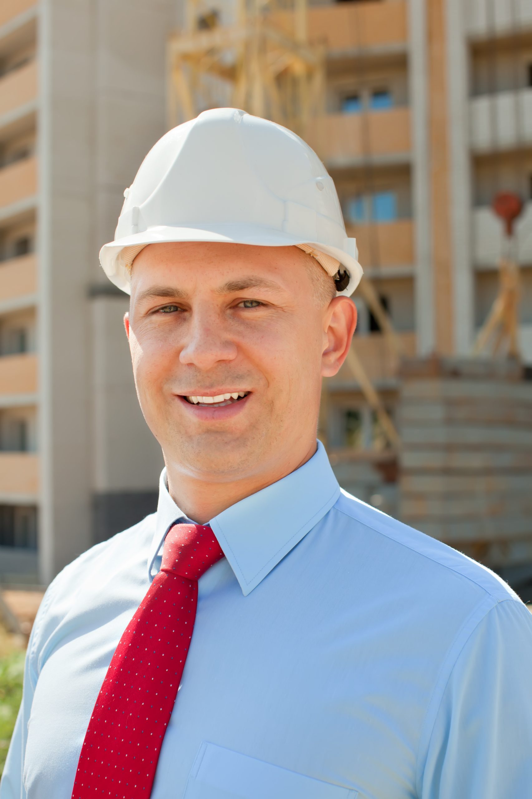 Happy builder in hardhat works on the building site