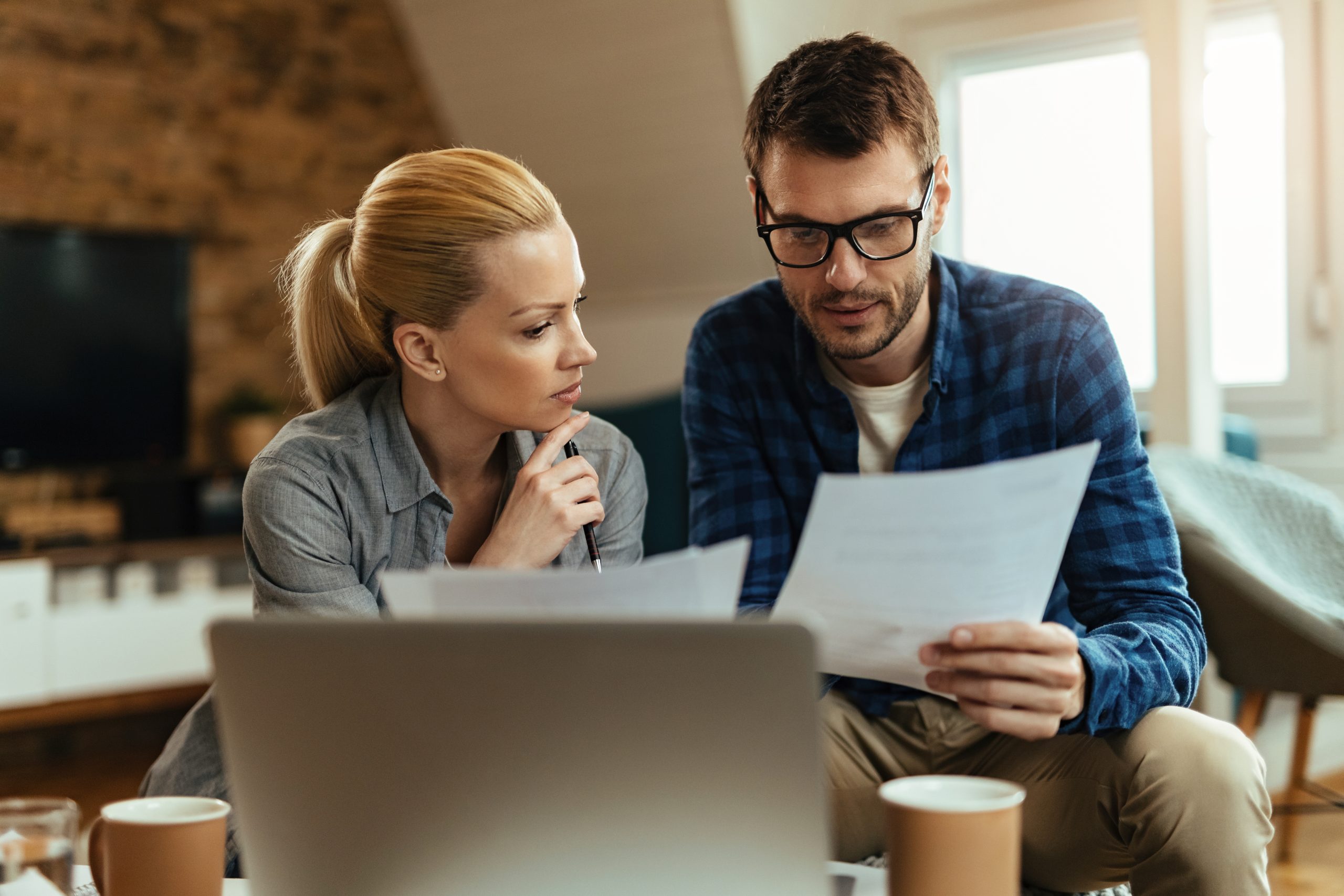 Young couple going through their finances while paying bills at home.